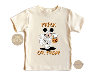 May include: A white t-shirt with a Mickey Mouse dressed as a mummy holding a pumpkin bucket. The text "Trick or Treat" is printed on the shirt.