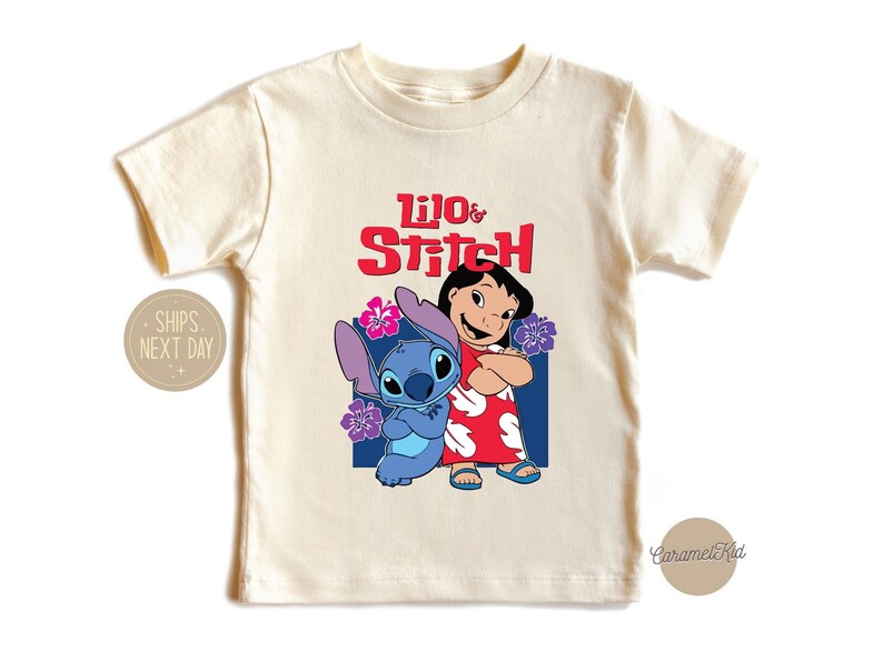 May include: A cream colored t-shirt with a graphic of Lilo and Stitch from the Disney movie. The text "Lilo & Stitch" is in red letters.