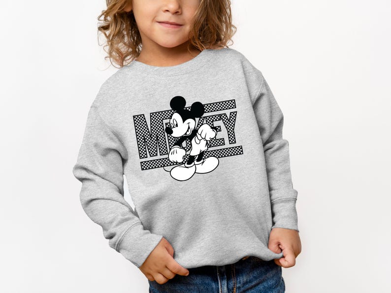 May include: A gray sweatshirt with a black and white graphic of Mickey Mouse and the word "Mickey" printed on it.
