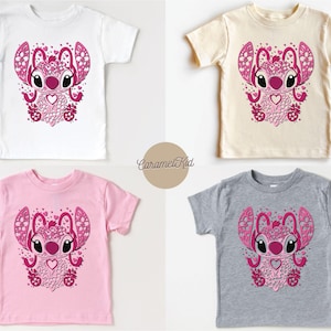 May include: Four different color t-shirts featuring a pink and white cartoon character with a heart and flowers. The character is surrounded by hearts and flowers. The t-shirts are available in white, pink, grey, and beige.