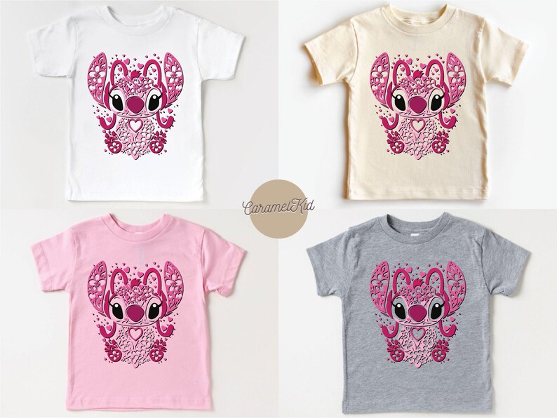 May include: Four different color t-shirts featuring a pink and white cartoon character with a heart and flowers. The character is surrounded by hearts and flowers. The t-shirts are available in white, pink, grey, and beige.