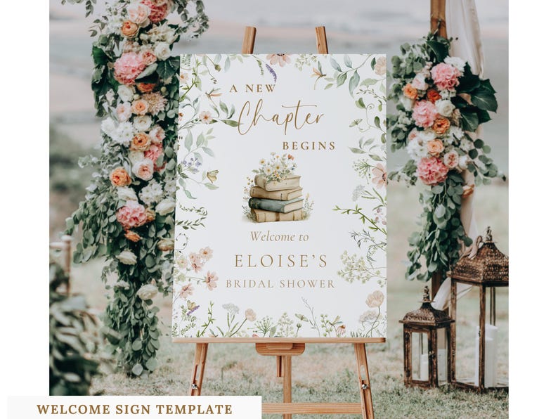 May include: A rectangular welcome sign on a wooden easel featuring a floral border with green leaves and pink, white, and yellow flowers. The text reads A NEW CHAPTER BEGINS, an illustration of stacked books, and WELCOME TO ELOISE'S BRIDAL SHOWER.