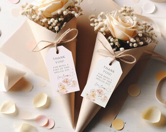 May include: Two small bouquets of dried flowers in brown paper cones with thank you tags attached. The tags are white with pink floral designs and the text "Thank You! For being a part of this special day".