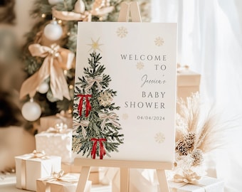 May include: A white rectangular sign on a wooden easel featuring a watercolor illustration of a green Christmas tree decorated with red and beige bows and a gold star. The text reads Welcome to Jessica's Baby Shower and the date 04/04/2024.