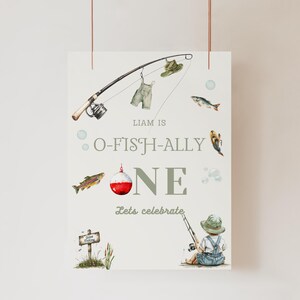 May include: A watercolour illustration of a fishing-themed sign. It features a fishing rod, fish, and the text "O-FISH-ALLY ONE." A small illustration of a child fishing is at the bottom. The sign is designed for a first birthday celebration.