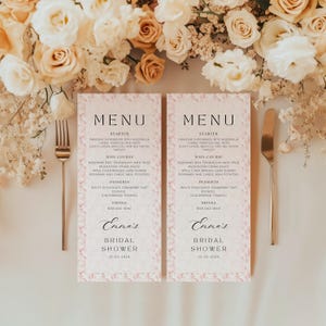 May include: Two pink and white floral patterned menus with the text "MENU" in black. The menus list the starter, main course, desserts, and drinks for a bridal shower. The text "Emma's Bridal Shower 01-03-2024" is at the bottom of each menu.