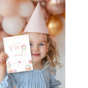 Op de afbeelding: Een meisje met een roze feestmuts houdt een verjaardagsuitnodiging vast waarop staat "Lily is Two Sweet" met een donut, een ijshoorn en andere zoetigheden erop afgebeeld.