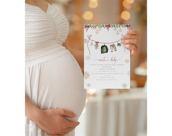 May include: A baby shower invitation held by a pregnant person. The invitation features a clothesline with baby clothes and the words "santa baby." The invitation has a festive design with snowflakes and greenery.