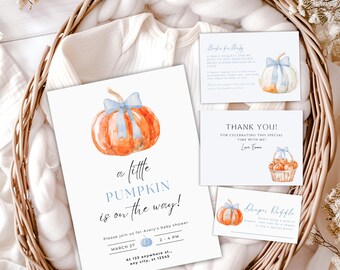 May include: A baby shower invitation and accompanying cards featuring watercolor pumpkins with blue bows. The main invitation reads "a little PUMPKIN is on the way!" and includes event details. The cards are in a woven basket.