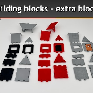 Pode incluir: Um conjunto de blocos de construção em preto, cinza e vermelho. Os blocos são de várias formas, incluindo quadrados, retângulos e triângulos. Os blocos estão dispostos em filas sobre uma superfície branca. Building blocks - extra blocks