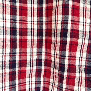 May include: Red, white, and black plaid fabric with a woven texture.