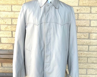 May include: A light beige long-sleeved jacket with a button-up front and a pointed collar. The jacket has a single chest pocket and two side pockets.