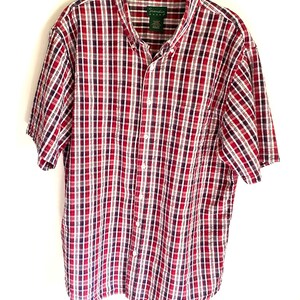 May include: A red, white, and blue plaid short-sleeved button-down shirt with the brand name "Granda" on the label.