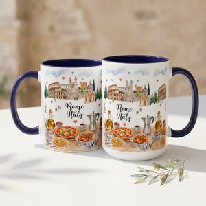 Pode incluir: Duas canecas de cer&acirc;mica branca com interior e al&ccedil;a azuis. Cada caneca apresenta uma ilustra&ccedil;&atilde;o em aquarela de Roma, It&aacute;lia, incluindo o Coliseu e outros marcos, juntamente com pizza, massa e o texto "Rome Italy."