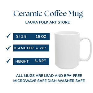 Pode incluir: Uma caneca de caf&eacute; de cer&acirc;mica branca com uma al&ccedil;a. A caneca tem 15 oz, com um di&acirc;metro de 12,1 cm e uma altura de 8,6 cm. O texto na imagem diz "Ceramic Coffee Mug" e "LAURA FOLK ART STORE."