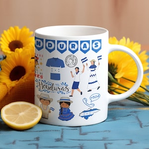 May include: White ceramic mug with a colorful design featuring Honduran cultural elements, including a flag, a woman in traditional dress, and the text "Honduras".