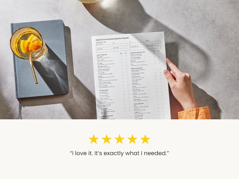 K&ouml;nnte beinhalten: Ein Glas mit orangenfarbenem Getr&auml;nk und goldenem Strohhalm liegt auf einem grauen Notizbuch. Eine Hand h&auml;lt eine gedruckte Checkliste mit der Aufschrift "Used Car Pre-Purchase Inspection Checklist". Das Bild enth&auml;lt eine Kundenrezension mit f&uuml;nf goldenen Sternen und dem Text "I love it. It's exactly what I needed."