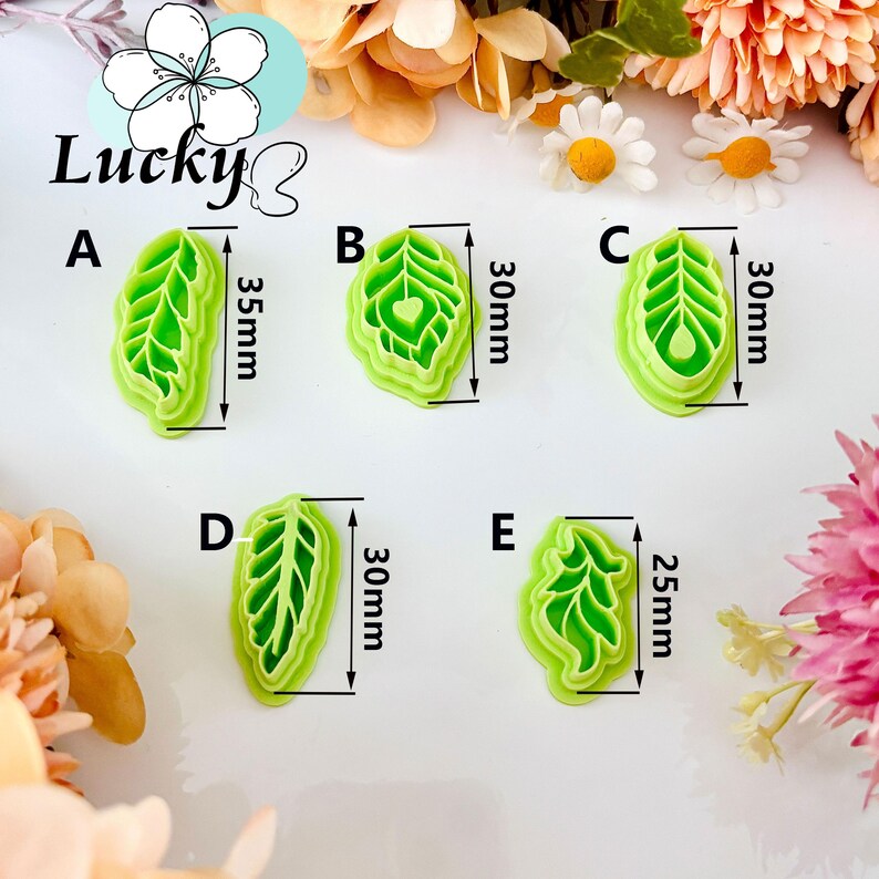 May include: Five green leaf-shaped cookie cutters. The cutters are labelled A to E, with dimensions ranging from 2.5cm to 3.5cm. The word "Lucky" is written in cursive above the cutters.