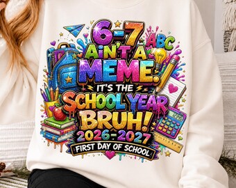 Puede incluir: Una sudadera de cuello redondo color crema con un estampado gráfico vibrante y multicolor que incluye material escolar como una mochila, libros, lápices y una calculadora. El texto dice 6-7 AIN'T A MEME. IT'S THE SCHOOL YEAR BRUH! 2026-2027 FIRST DAY OF SCHOOL.