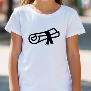 以下が含まれることがあります： 黒い卒業帽と卒業証書のグラフィックが描かれた白いTシャツ