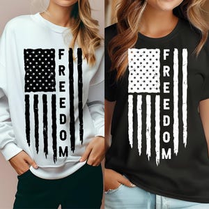 Könnte beinhalten: Weißes Sweatshirt und schwarzes T-Shirt mit einem verblassten amerikanischen Flaggen-Design. Die Flagge zeigt ein Sternenfeld und vertikale Streifen mit dem Wort "FREEDOM" vertikal in fetten, schwarzen Buchstaben. Geeignet für Freizeitkleidung.