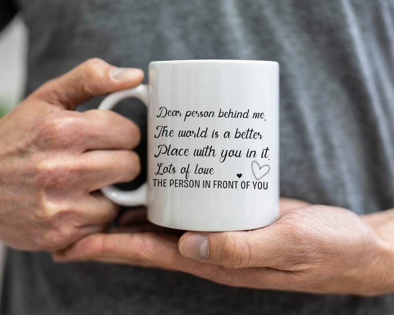 Pode incluir: Caneca de cer&acirc;mica branca com texto preto que diz "Querida pessoa atr&aacute;s de mim, O mundo &eacute; um lugar melhor com voc&ecirc; nele. Muito amor &hearts; A PESSOA NA FRENTE DE VOC&Ecirc;".