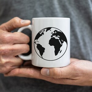 K&ouml;nnte beinhalten: Eine wei&szlig;e Keramiktasse mit einer schwarzen Umrandung der Erde.