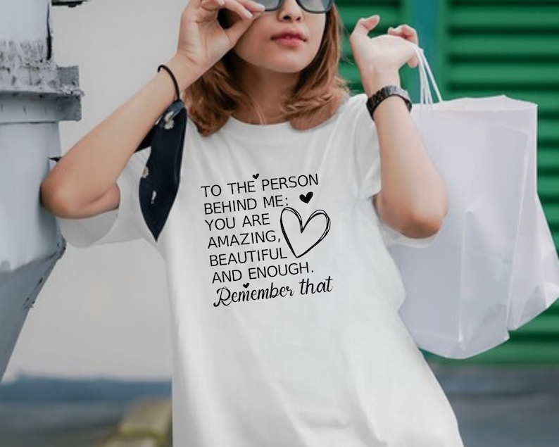 Pode incluir: Camiseta branca com um gr&aacute;fico preto que diz "To the person behind me: You are amazing, beautiful and enough. Remember that."