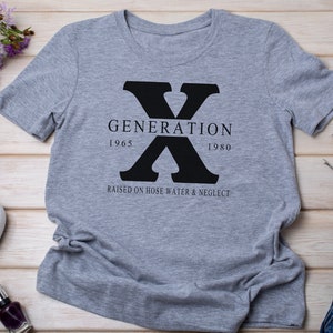 May include: Gray t-shirt with a black graphic of the letter X and the text "GENERATION 1965 1980 RAISED ON HOSE WATER & NEGLECT"