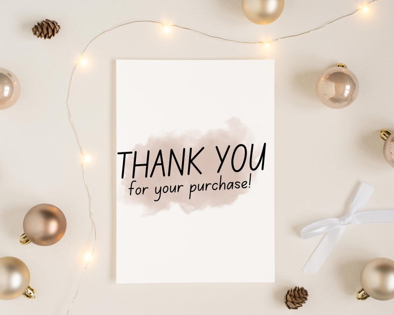 May include: A white card with the text "THANK YOU for your purchase!" written in black. The card is surrounded by gold ornaments and a string of white lights.