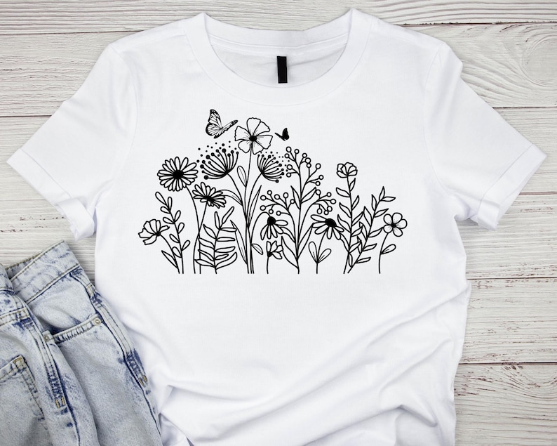 May include: White t-shirt with a black line drawing of a cluster of flowers and a butterfly.