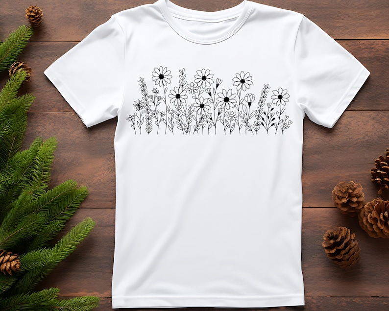 May include: White t-shirt with a black line drawing of a field of flowers.