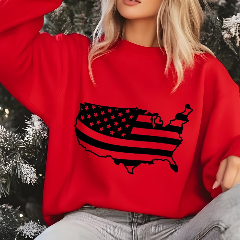 May include: A red sweatshirt featuring a black graphic of the United States map with a flag design. The flag design includes black stripes and stars. The sweatshirt is a solid red color.