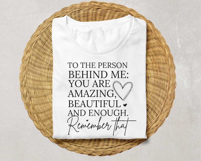Pode incluir: Camiseta branca com texto preto que diz "Para a pessoa atr&aacute;s de mim: Voc&ecirc; &eacute; incr&iacute;vel, linda e suficiente. Lembre-se disso."