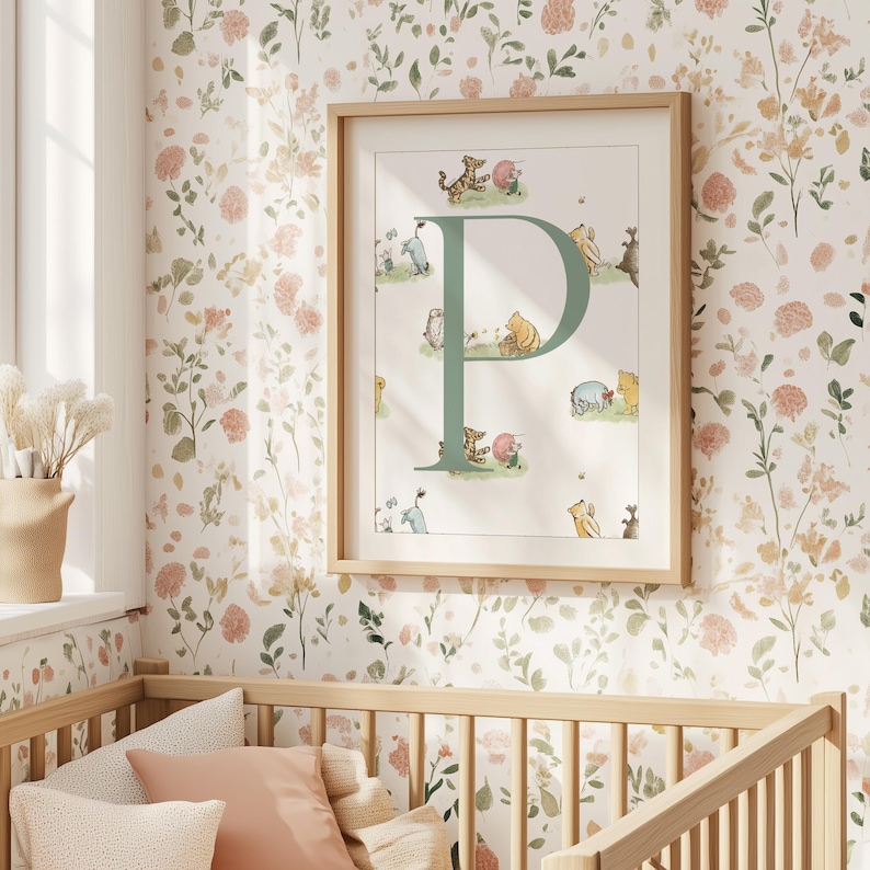 May include: A framed nursery print featuring a large green letter "P" with illustrations of Winnie the Pooh characters. The artwork is set against a white background and framed in light wood. The background is a floral wallpaper.