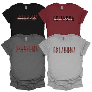K&ouml;nnte beinhalten: Vier kurz&auml;rmelige T-Shirts in Schwarz, Burgunderrot, Grau und Hellgrau. Jedes Shirt zeigt das Wort "OKLAHOMA" in fetter Schrift, darunter das Wort "sooners" in Schreibschrift. Freizeitkleidung.