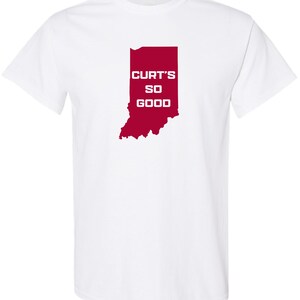 May include: White t-shirt featuring a red outline of the state of Indiana. The text "CURT'S SO GOOD" is printed in white within the state's borders. The shirt is made of a soft material and has short sleeves.