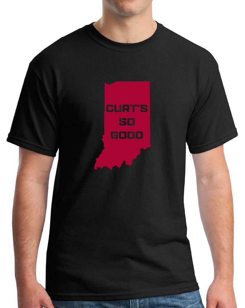 May include: Black t-shirt featuring a red outline of the state of Indiana with the text "CURT'S SO GOOD" in red block letters. The shirt is a crew neck style.