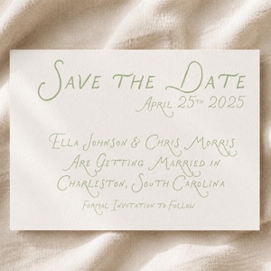 May include: A rectangular white card with sage green text that reads: Save the Date, April 25th 2025, Ella Johnson & Chris Morris are getting married in Charleston, South Carolina, Formal Invitation to Follow. The card has a textured paper finish.