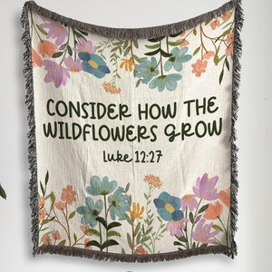 May include: A woven tapestry featuring a floral design and the text "CONSIDER HOW THE WILDFLOWERS GROW Luke 12:27".