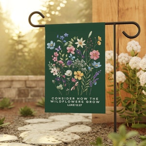May include: A green garden flag with a floral design and the text "Consider how the wildflowers grow Luke 12:27".