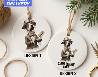 May include: Two white ceramic ornaments with dog illustrations. Design 1 features a dog in a suit and top hat holding sheet music. Design 2 has the same dog with the name "Charlie 2025". Both have twine hangers.