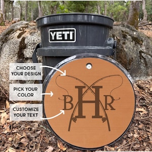 May include: A circular brown EVA foam pad for a bucket lid featuring a laser-engraved design of two crossed fishing rods and the monogram BHR. The pad includes text overlays stating CHOOSE YOUR DESIGN, PICK YOUR COLOR, and CUSTOMIZE YOUR TEXT.