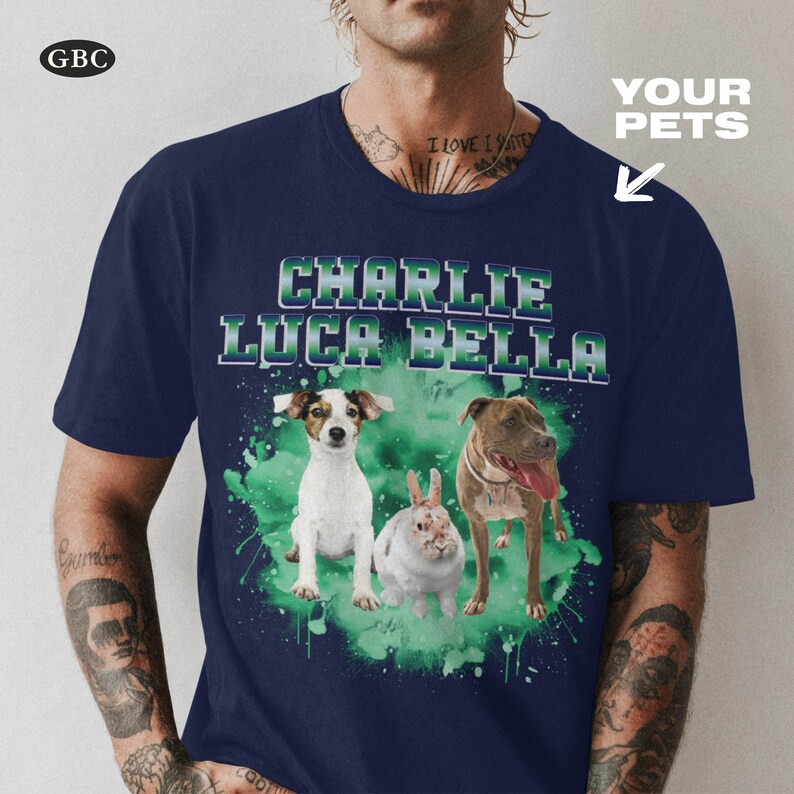 May include: A navy blue t-shirt with a green watercolor splatter design featuring three pets: a white dog, a brown and white dog, and a white rabbit. The names "Charlie", "Luca", and "Bella" are printed in white on the shirt.