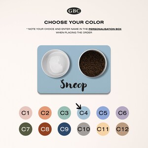 Op de afbeelding: Een blauwe en witte hondenvoerset met de naam "Snoop" op de mat. De set bevat twee kommen en een mat. De mat is verkrijgbaar in 12 kleuren, zoals te zien op de afbeelding. De kleuren zijn gemarkeerd met C1 tot en met C12.