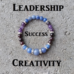 May include: A beaded bracelet with blue, purple, and red stones. The bracelet has the word "Success" in the center. The words "Leadership" and "Creativity" are at the top and bottom of the image.