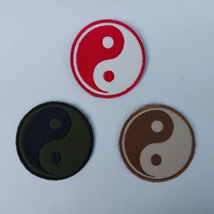 May include: Three embroidered yin yang patches in different colors: red and white, black and green, and brown and beige.