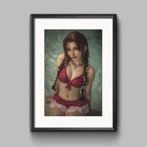 May include: Framed print featuring a woman in a red bikini top and matching ruffled shorts. Her long, braided hair is adorned with flowers. The image is set against a blurred, aquatic background, creating a serene and artistic composition.