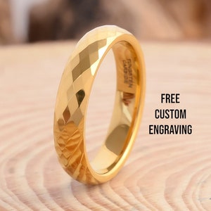 Op de afbeelding: Een gouden ring van wolframcarbide met een diamantgeslepen ontwerp. De ring is gegraveerd met "TUNGSTEN CARBIDE". GRATIS AANPASSING GRAVURE.