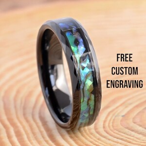 Peut inclure: Bague en carbure de tungstène noir avec une incrustation d'abalone vert, bleu et iridescent. GRAVURE PERSONNALISÉE GRATUITE.